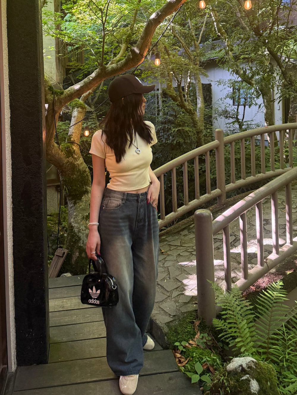 イエロー系のTシャツ/カットソー、その他のハンドバッグ、ブルー系のデニムパンツを着用したレディースの夏コーディネートの2枚目の写真