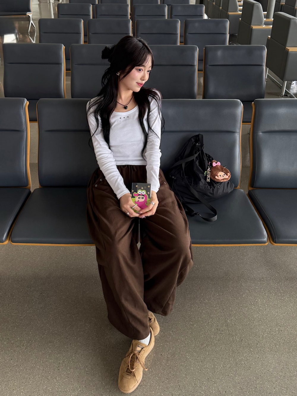 ホワイト系のTシャツ/カットソー、ブラウン系のスウェットパンツ、ブラウン系のスニーカーを着用したレディースの秋コーディネートの2枚目の写真