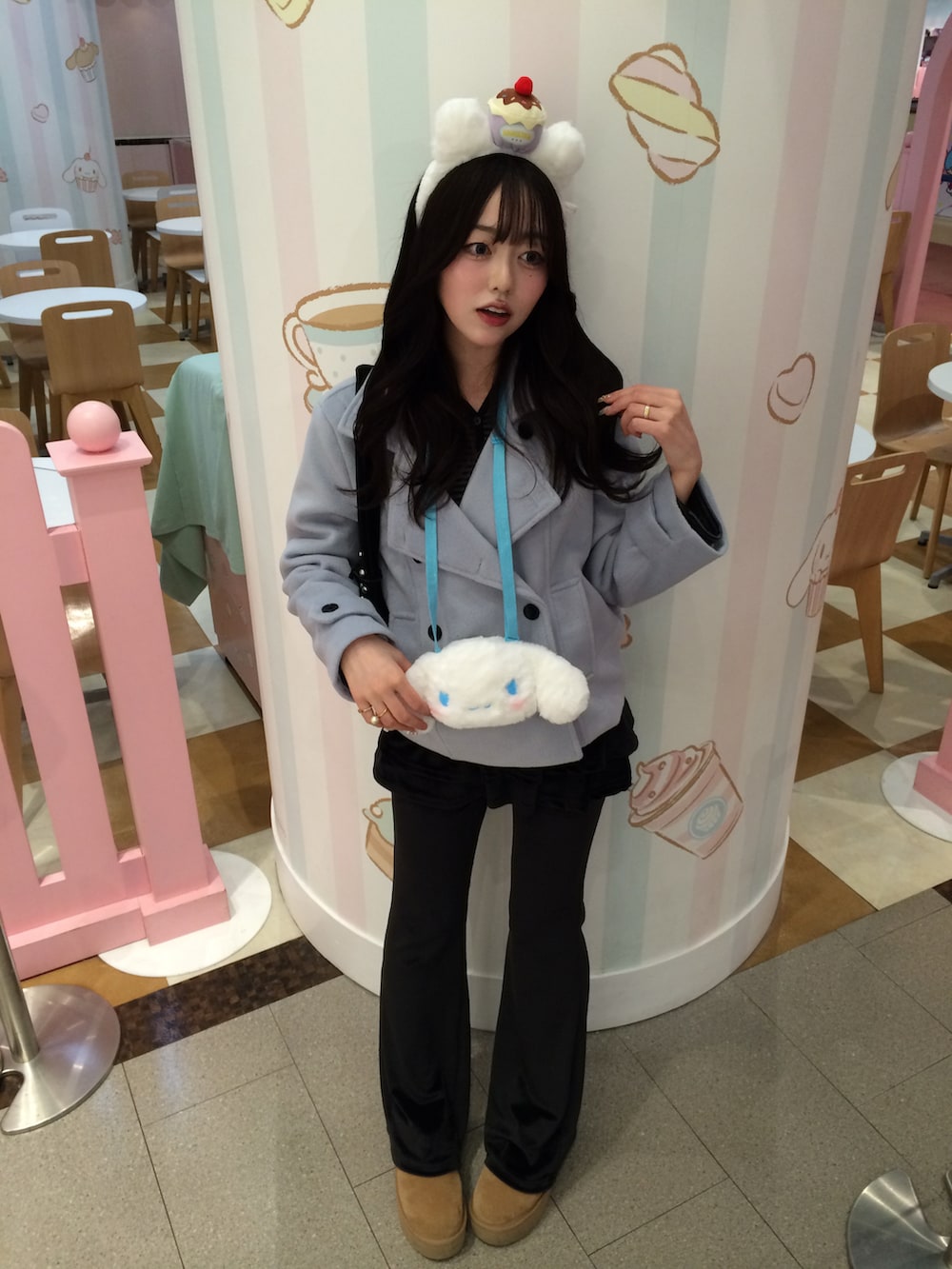 ブラウン系のブーツ、ブルー系のノーカラーコート、ブラック系のパンツを着用したレディースの冬コーディネートの2枚目の写真