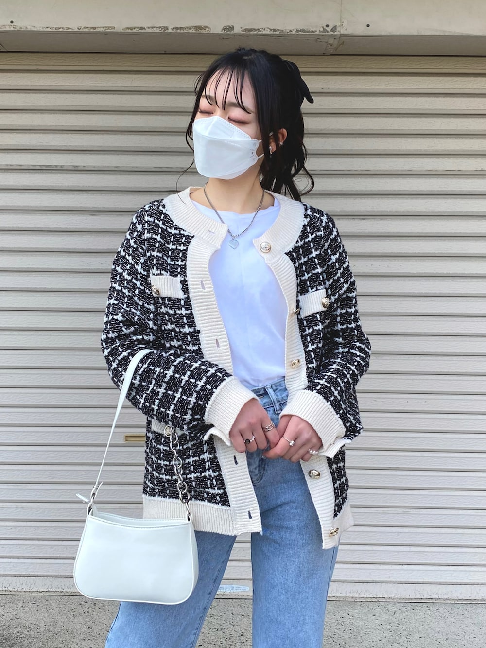 ホワイト系のスニーカー、ホワイト系のショルダーバッグ、ブラック系のカーディガン/ボレロを着用したレディースの春コーディネートの4枚目の写真