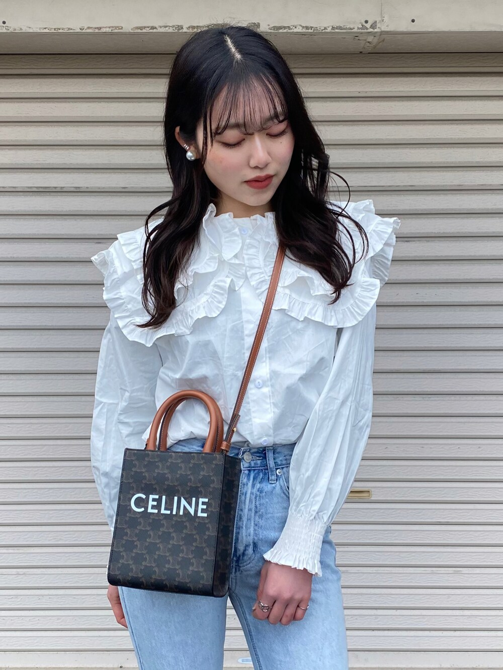 ホワイト系のTシャツ/カットソー、ブルー系のデニムパンツ、ブラック系のローファーを着用したレディースの冬コーディネートの4枚目の写真