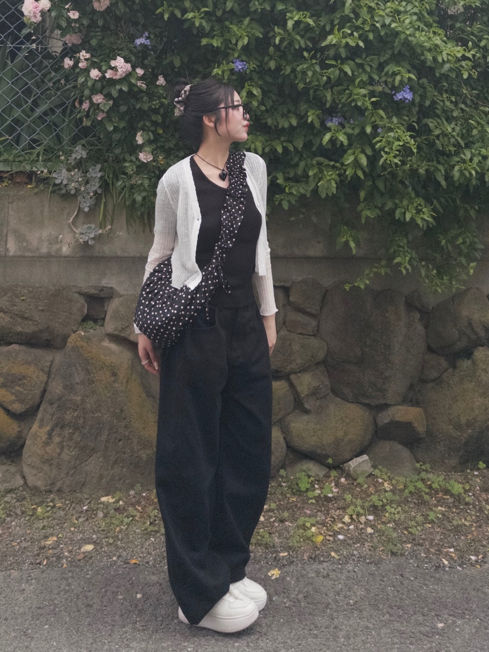 ブラック系のTシャツ/カットソー、ブラック系のショルダーバッグ、ブラック系のデニムパンツを着用したレディースの春コーディネートの2枚目の写真