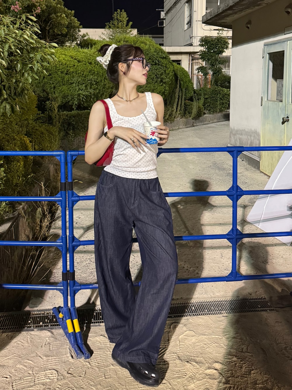 ホワイト系のタンクトップ、ブルー系のデニムパンツ、ブラック系のサンダルを着用したレディースの夏コーディネートの2枚目の写真