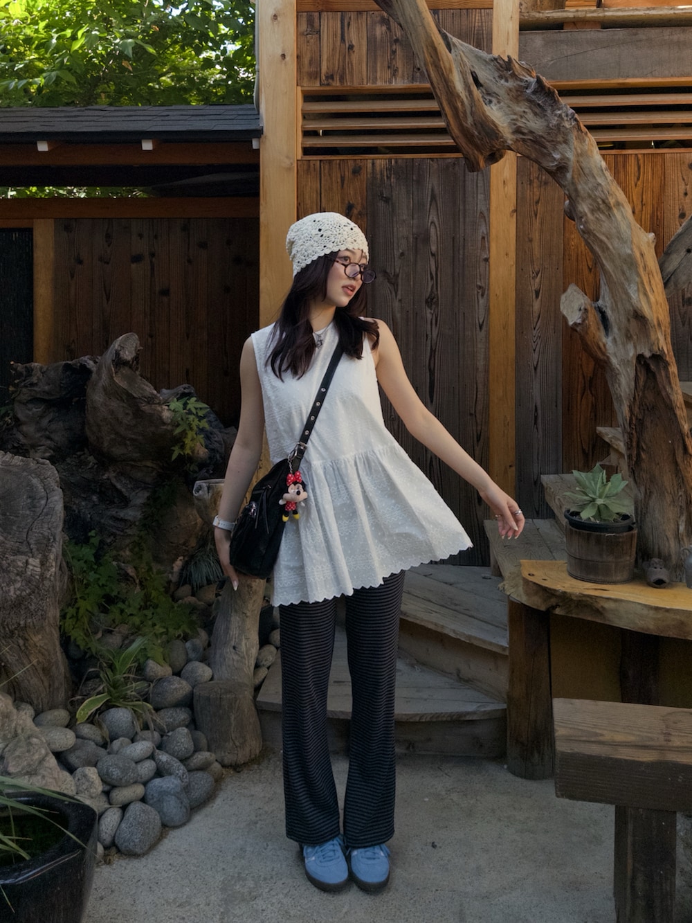 ホワイト系のワンピース、ブラック系のショルダーバッグ、ブルー系のスニーカーを着用したレディースの春コーディネートの2枚目の写真