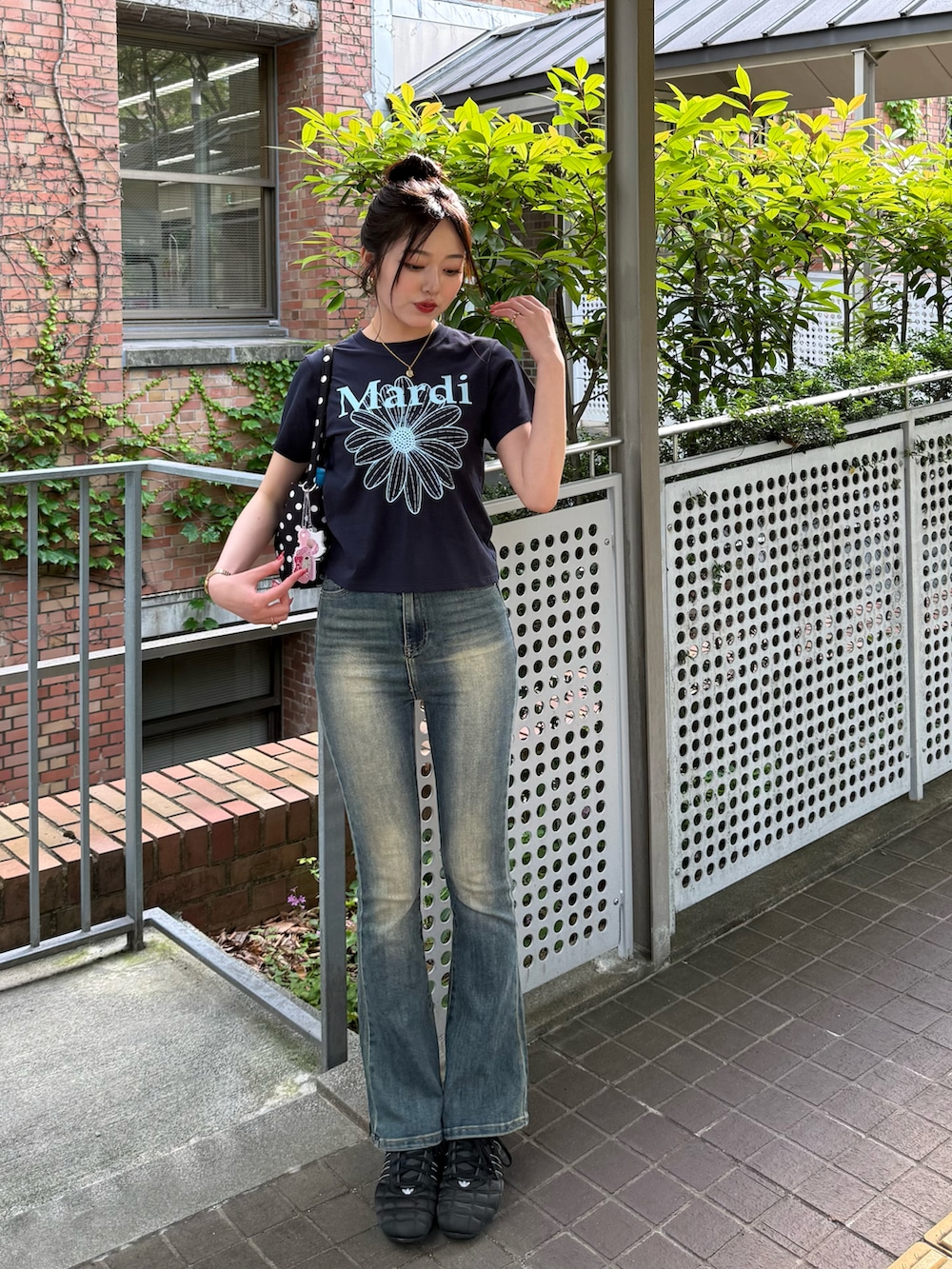 ブルー系のTシャツ/カットソー、ブルー系のデニムパンツ、ブラック系のスニーカーを着用したレディースの夏コーディネートの2枚目の写真
