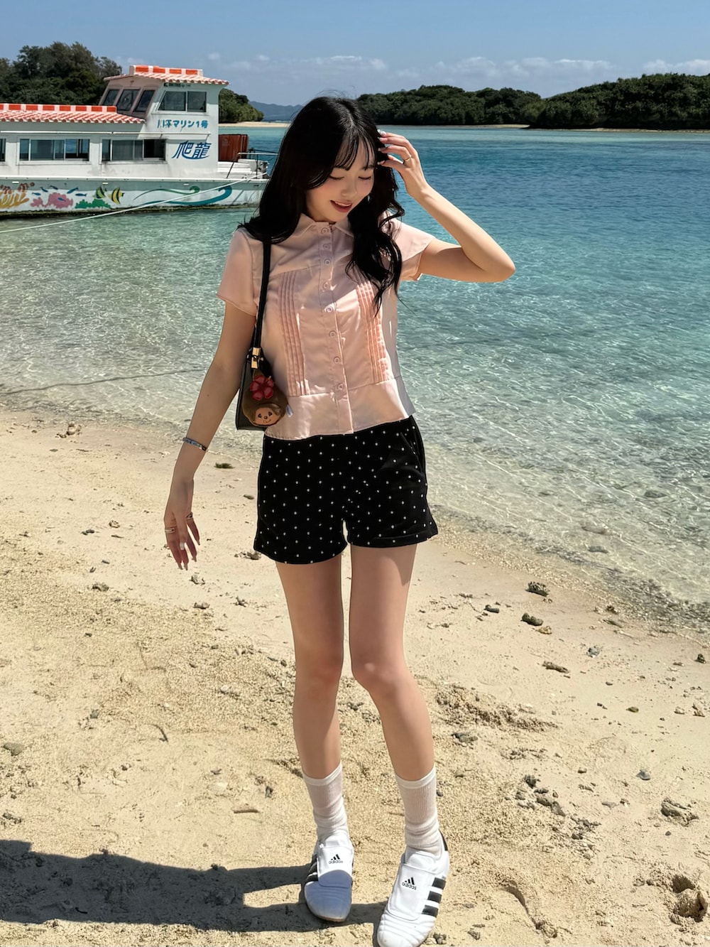 ピンク系のシャツ/ブラウス、ブラック系のパンツ、ホワイト系のスニーカーを着用したレディースの春コーディネートの2枚目の写真