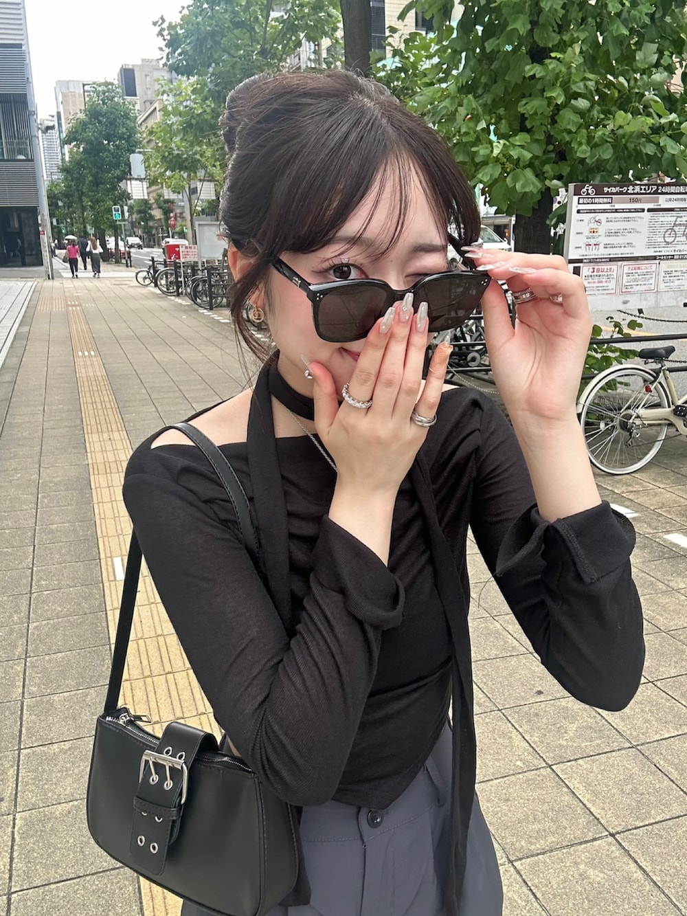 ホワイト系のスニーカー、ブラック系のサングラスを着用したレディースの冬コーディネートの2枚目の写真