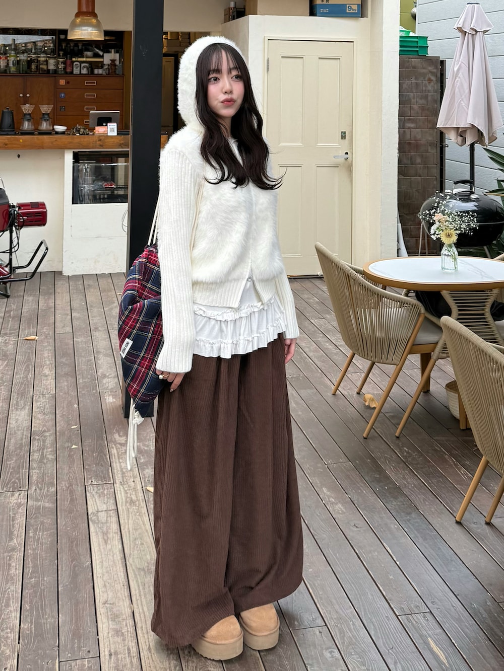 ホワイト系のニット/セーター、その他のバッグ、ブラウン系のパンツを着用したレディースの冬コーディネートの2枚目の写真