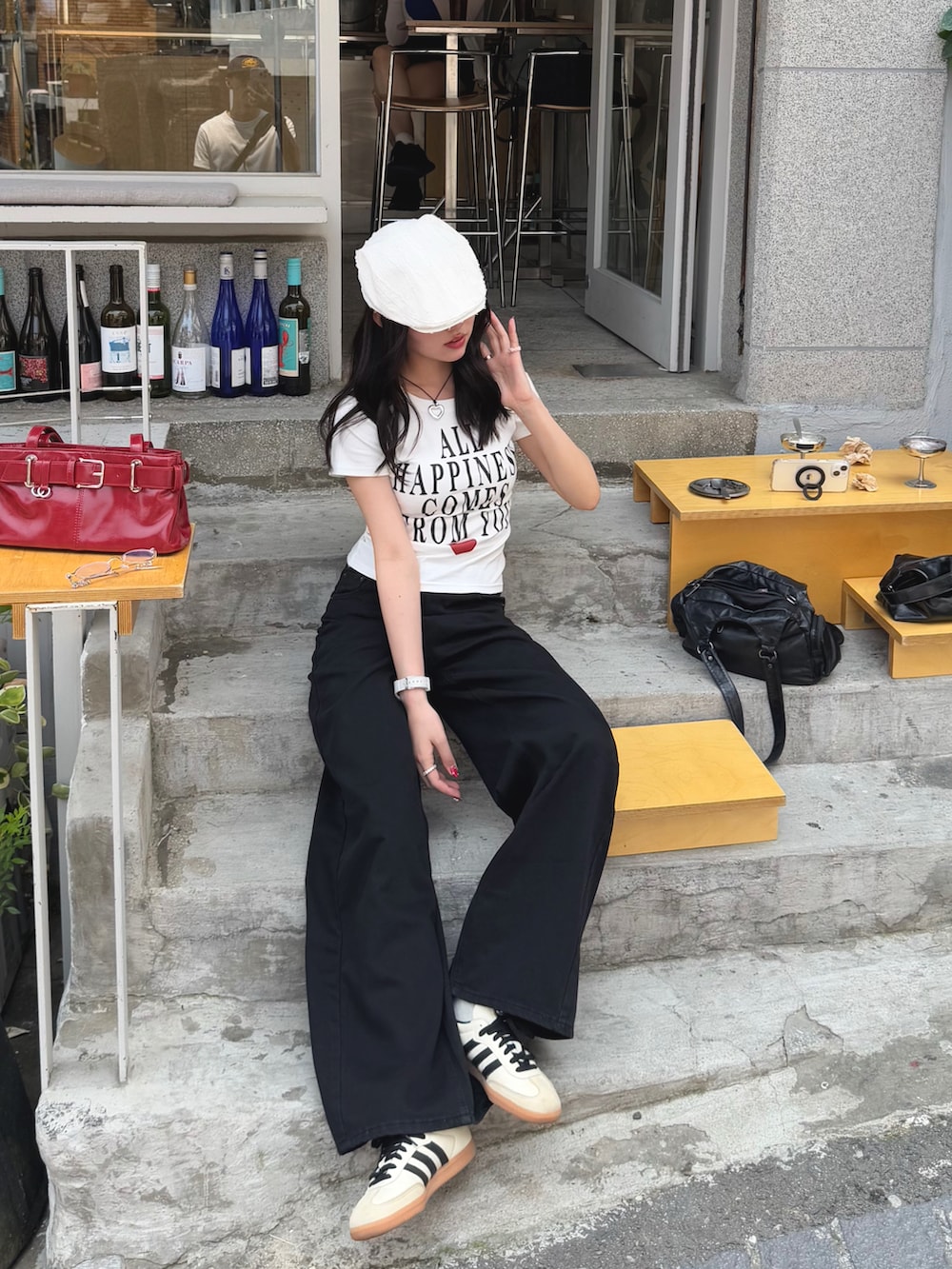 ホワイト系のTシャツ/カットソー、ブラック系のデニムパンツ、ホワイト系のスニーカーを着用したレディースの春コーディネートの2枚目の写真