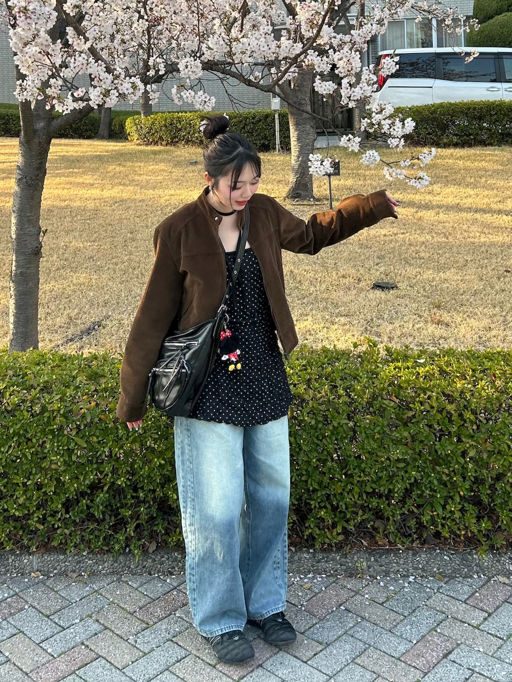 ブラック系のキャミソール、ブラウン系のジャケット/アウター、ブラック系のショルダーバッグを着用したレディースの春コーディネートの2枚目の写真