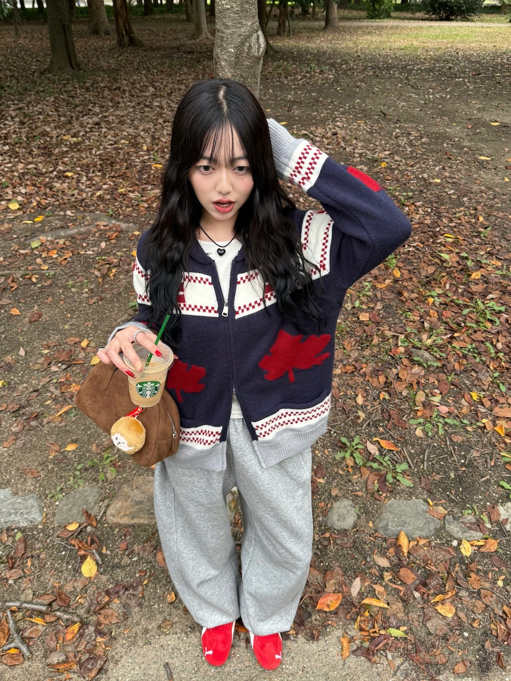 レッド系のスニーカー、ブルー系のニット/セーター、グレー系のスウェットパンツを着用したレディースの秋コーディネートの3枚目の写真