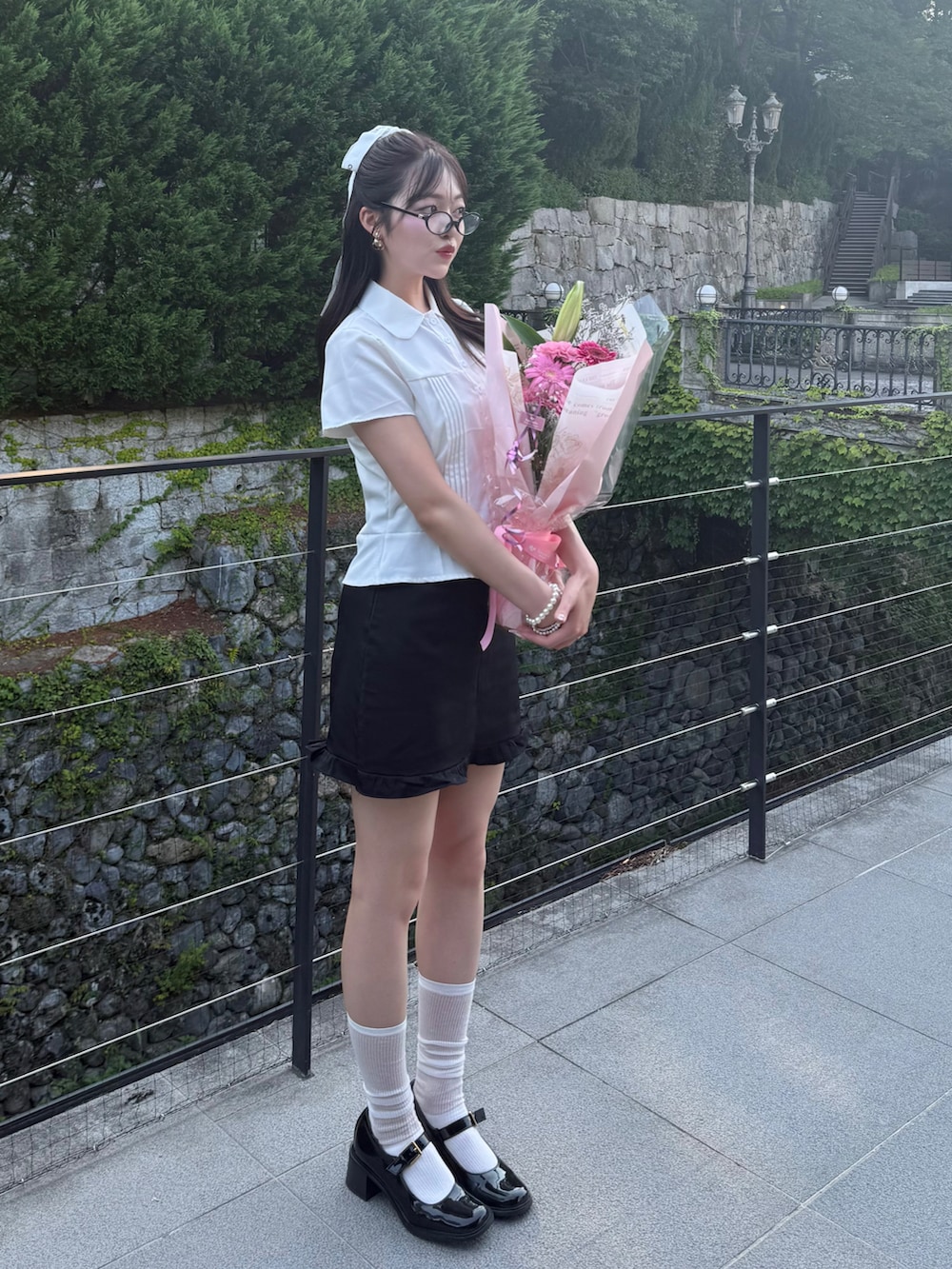 ホワイト系のシャツ/ブラウス、ブラック系のスカート、ブラック系のパンプスを着用したレディースの夏コーディネートの2枚目の写真