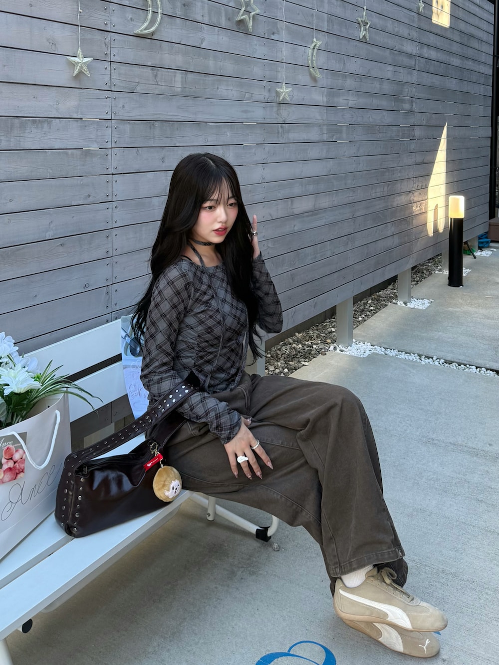 ブラウン系のデニムパンツ、その他のTシャツ/カットソー、ブラウン系のハンドバッグを着用したレディースの秋コーディネートの2枚目の写真