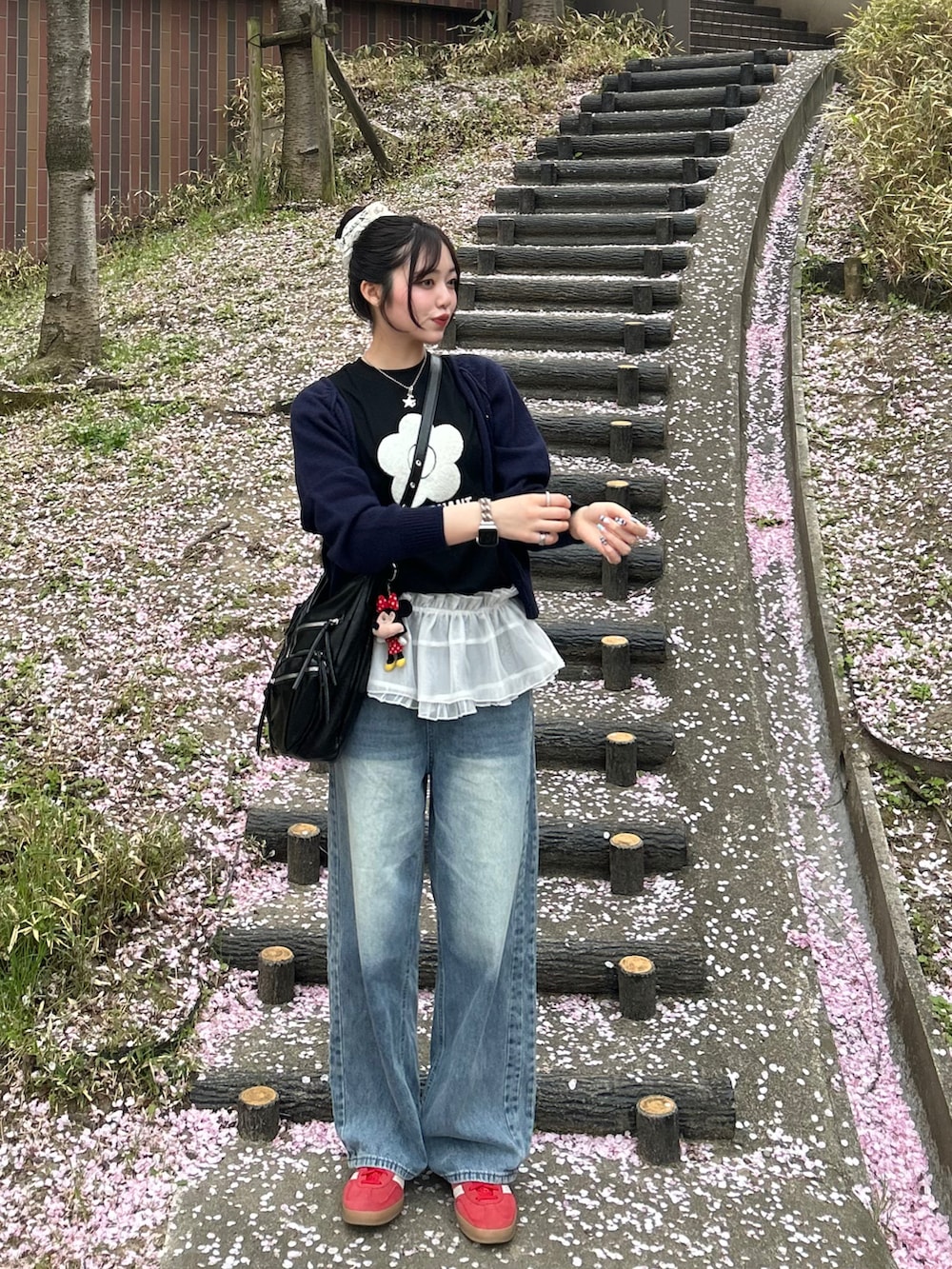 ブラック系のTシャツ/カットソー、レッド系のスニーカー、ブラック系のショルダーバッグを着用したレディースの春コーディネートの2枚目の写真