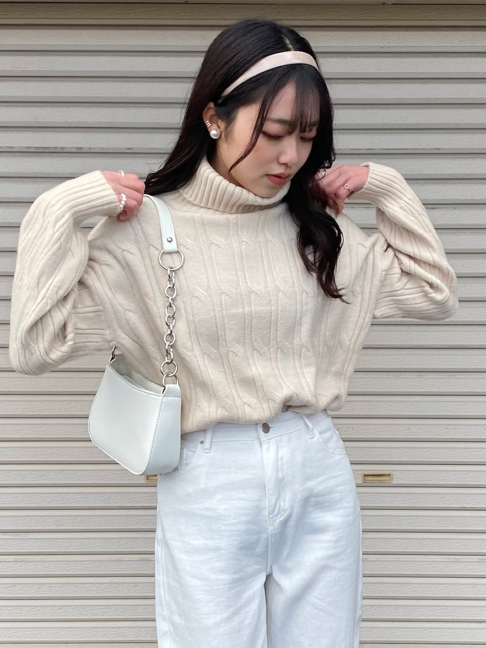 ホワイト系のスニーカー、ホワイト系のニット/セーター、ホワイト系のショルダーバッグを着用したレディースの冬コーディネートの4枚目の写真