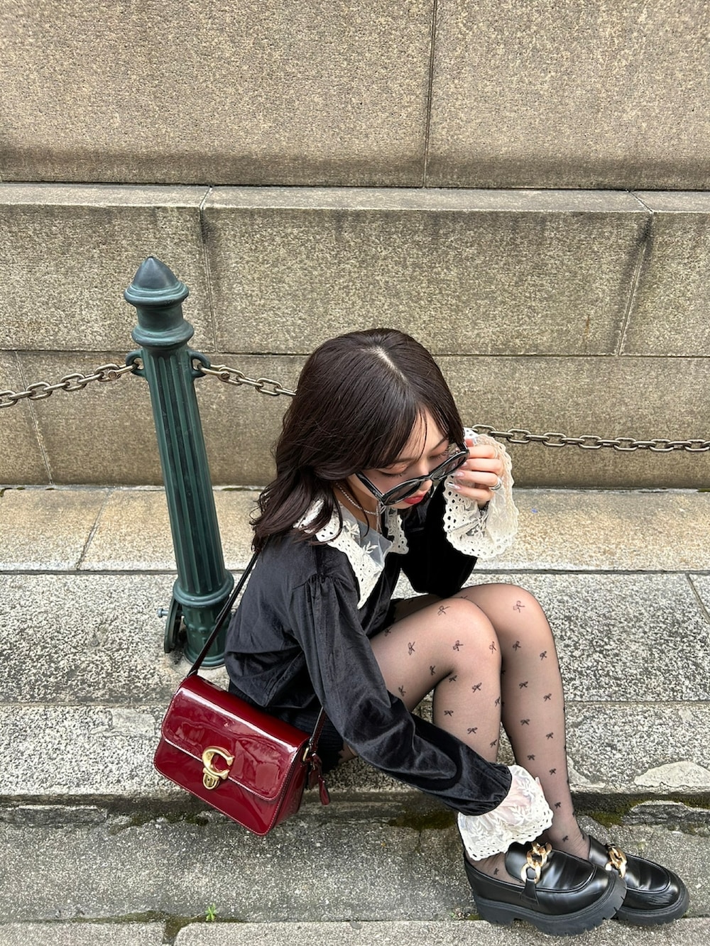 ブラック系のニット/セーター、レッド系のショルダーバッグ、ブラック系のその他パンツを着用したレディースの冬コーディネートの4枚目の写真