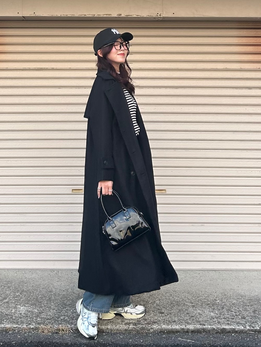 ブラック系のニット/セーター、ブルー系のデニムパンツ、ブラック系のボストンバッグを着用したレディースの冬コーディネートの3枚目の写真