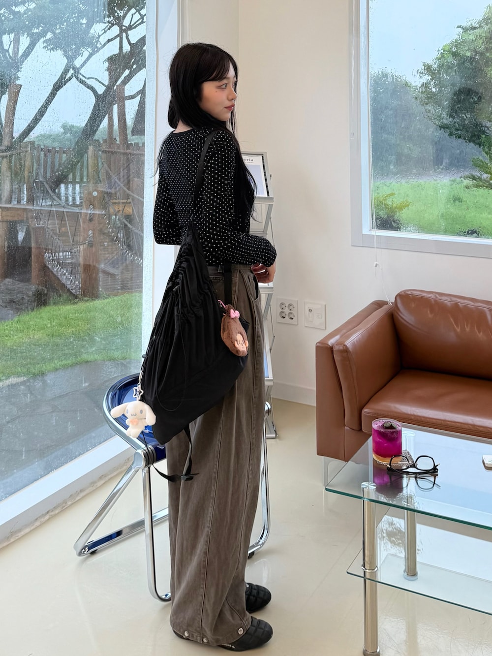 ブラック系のTシャツ/カットソー、ブラック系のスニーカー、ブラウン系のデニムパンツを着用したレディースの秋コーディネートの2枚目の写真