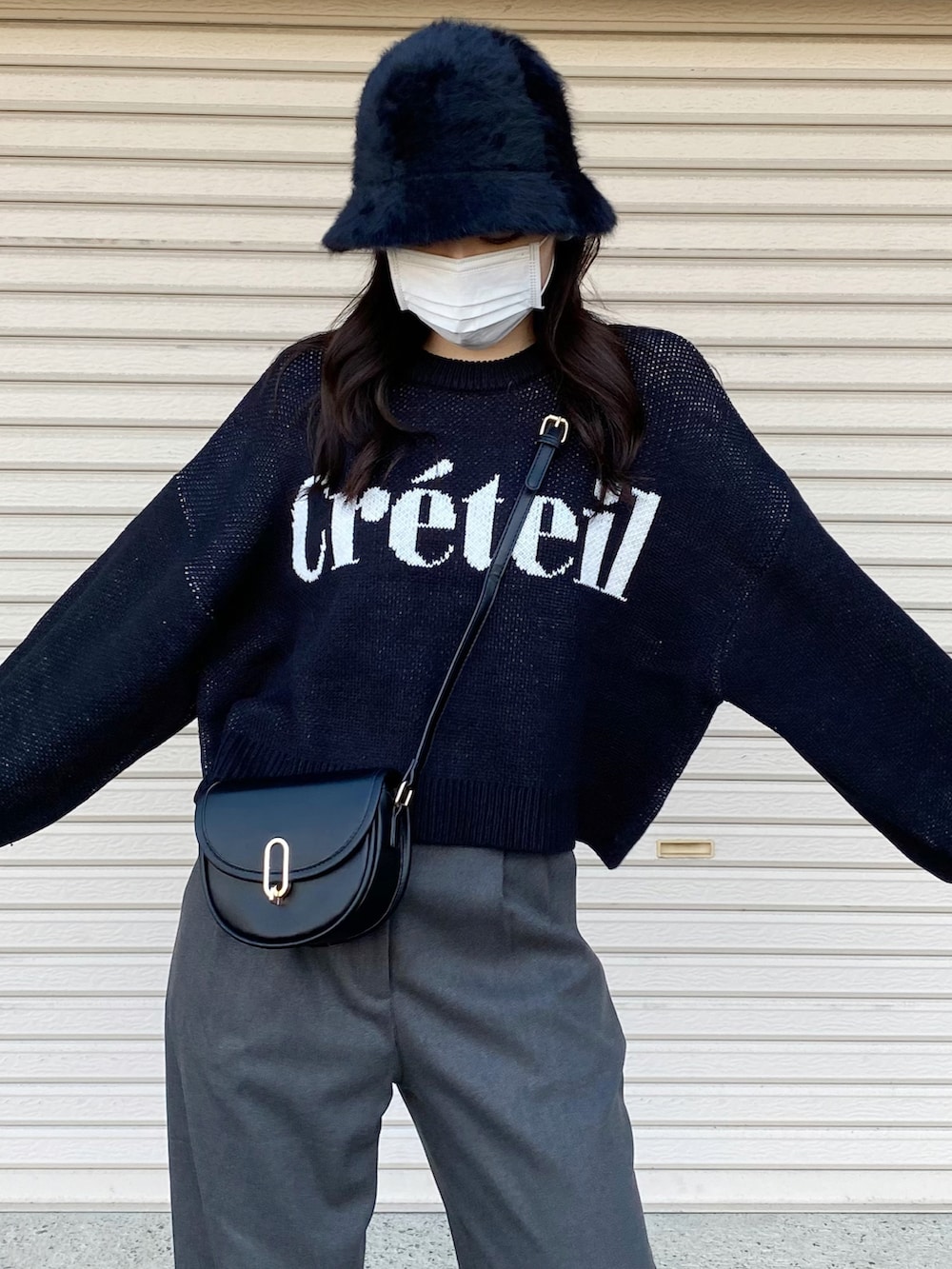 ブラック系のニット/セーター、ホワイト系のスニーカー、ブラック系のハットを着用したレディースの冬コーディネートの3枚目の写真