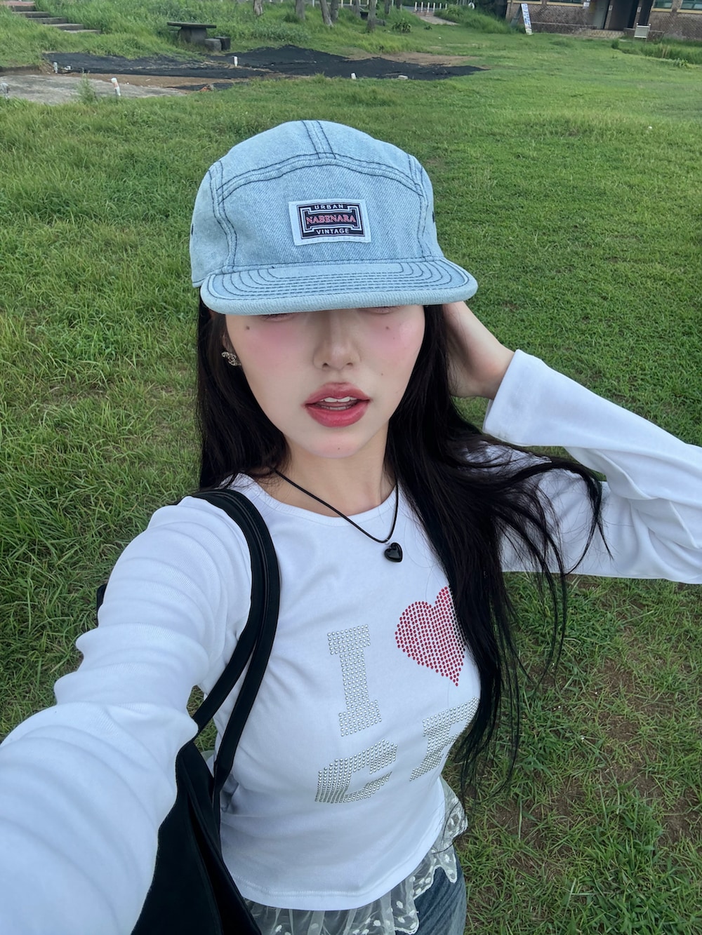 ホワイト系のTシャツ/カットソー、ブルー系のデニムパンツ、ブラック系のスニーカーを着用したレディースの秋コーディネートの2枚目の写真