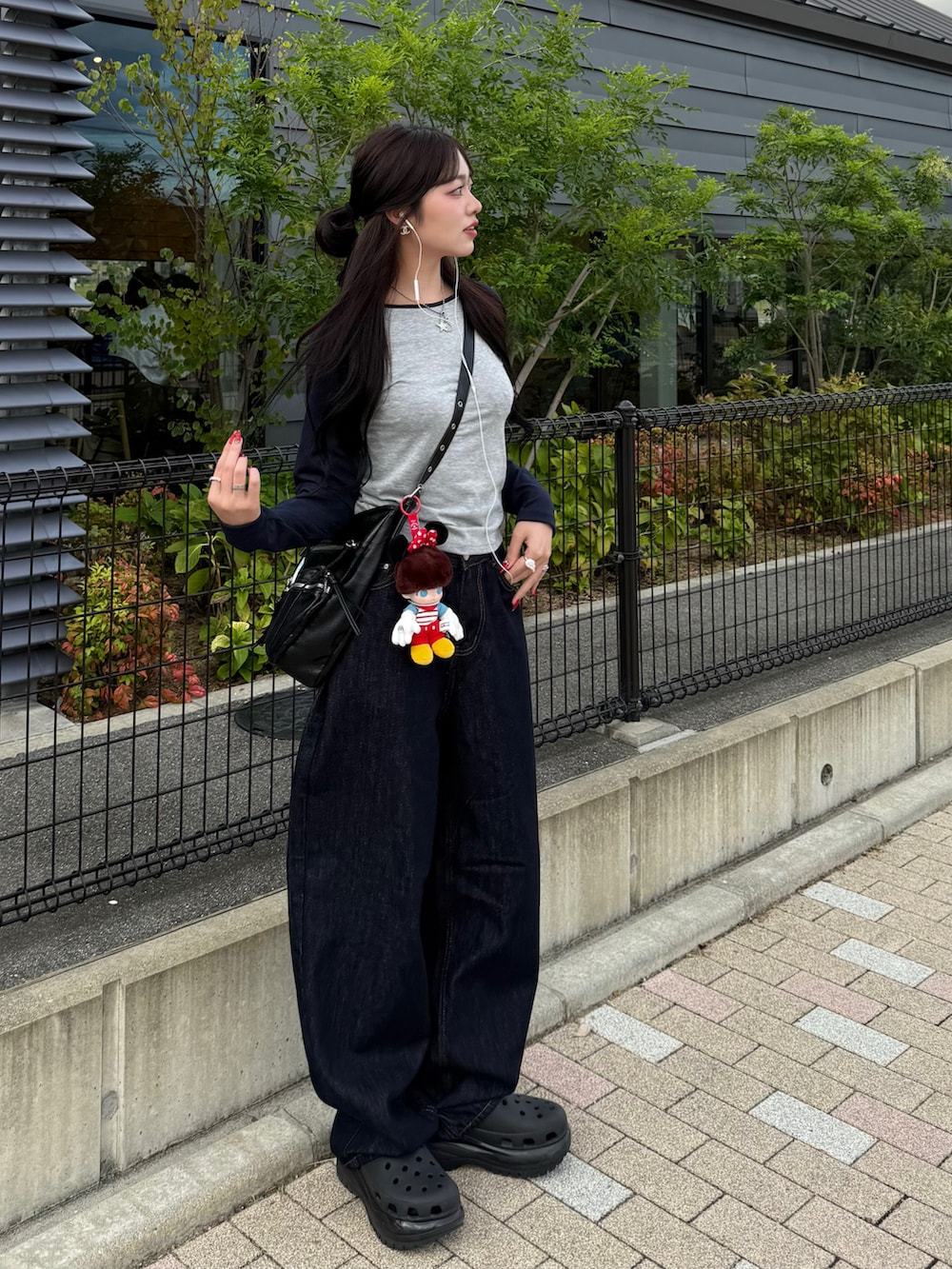 ブラック系のサンダル、グレー系のTシャツ/カットソー、ブルー系のデニムパンツを着用したレディースの秋コーディネートの3枚目の写真