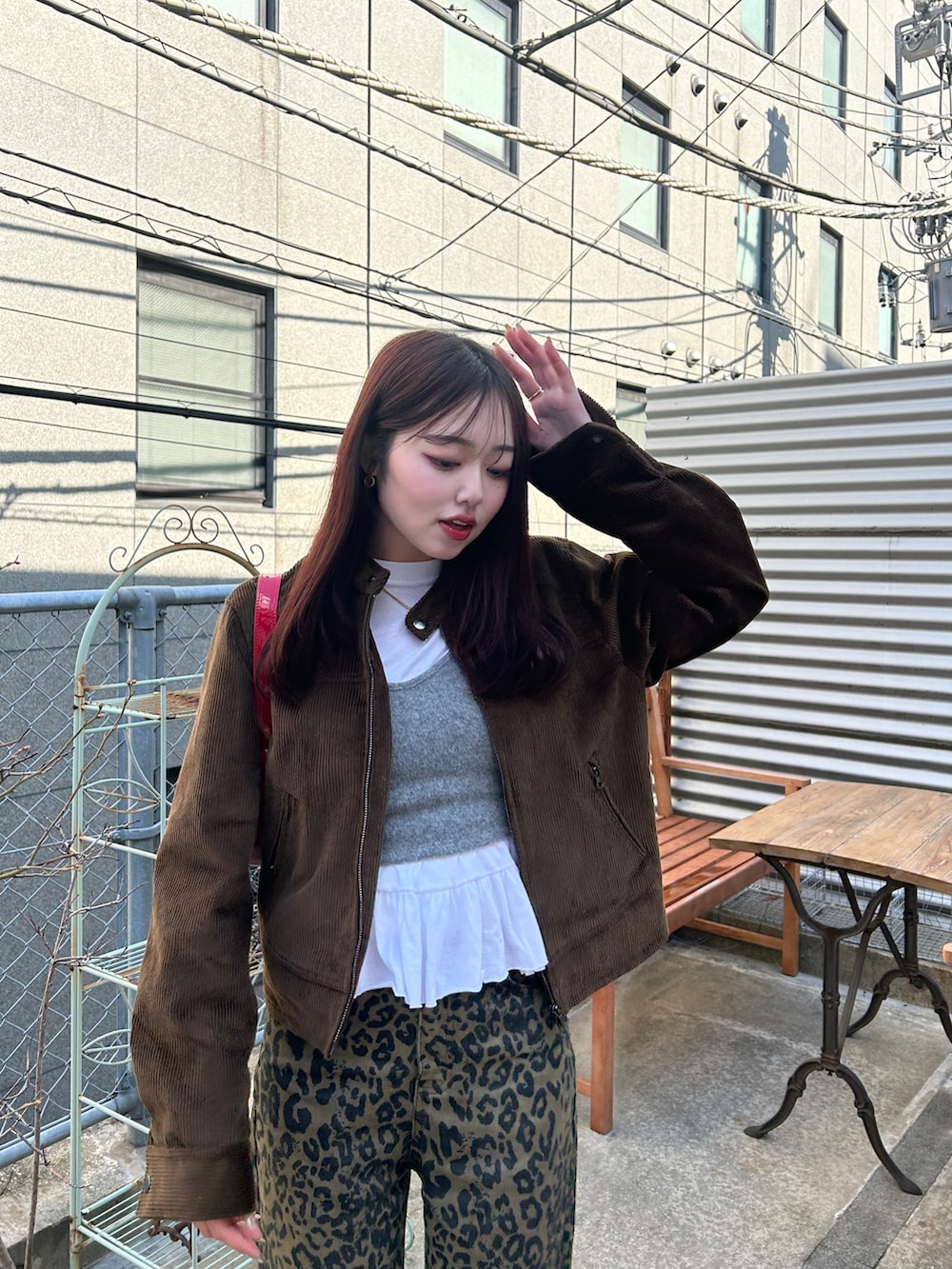 ブラウン系のデニムパンツ、レッド系のスニーカー、レッド系のハンドバッグを着用したレディースの春コーディネートの3枚目の写真