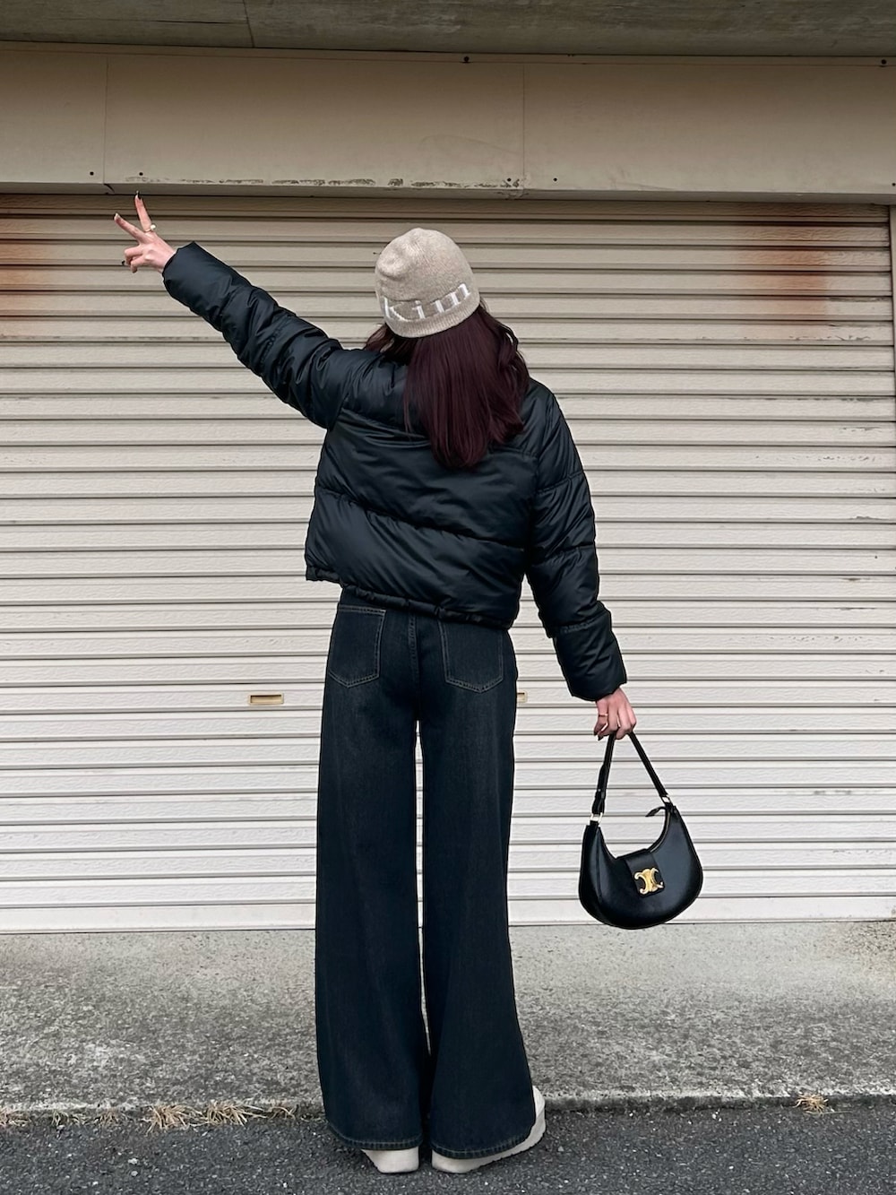 ブラック系のダウンジャケット/コート、ブラック系のデニムパンツ、ベージュ系のブーツを着用したレディースの冬コーディネートの3枚目の写真