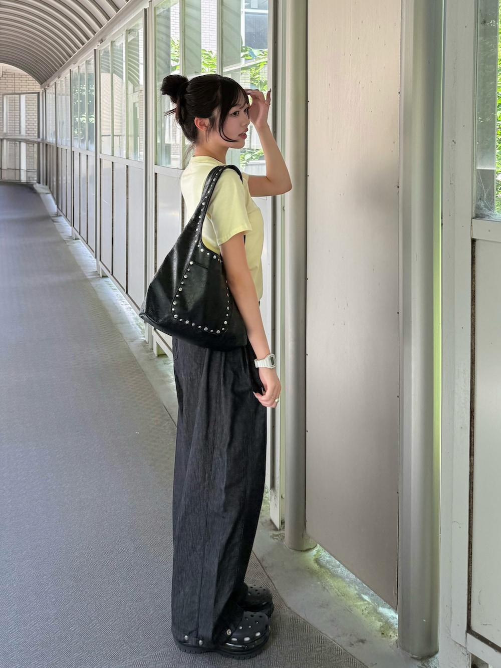 イエロー系のTシャツ/カットソー、ブラック系のサンダル、ブルー系のデニムパンツを着用したレディースの夏コーディネートの2枚目の写真