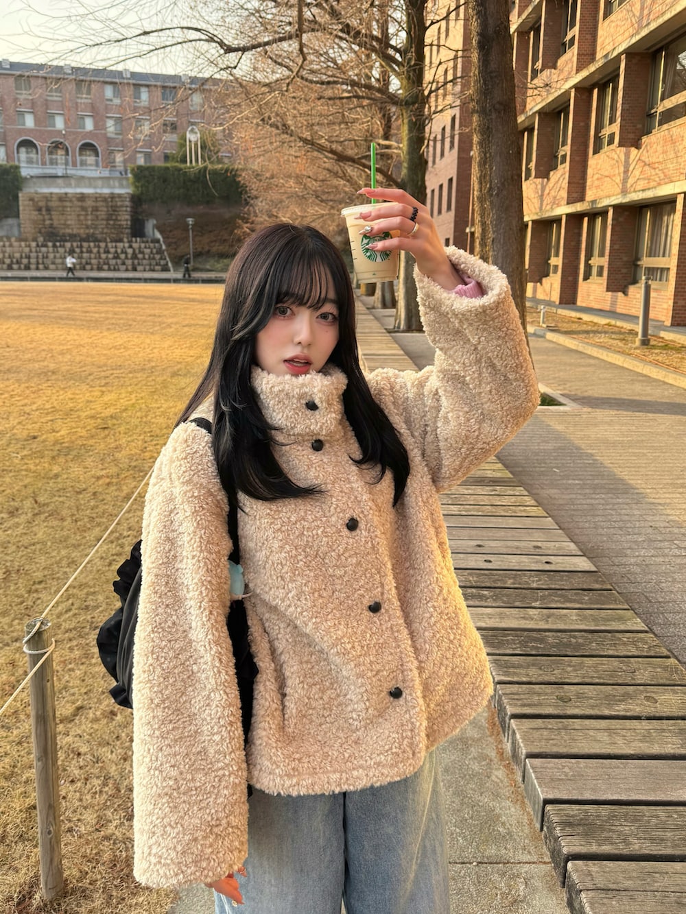 ベージュ系のその他アウター、ブルー系のデニムパンツ、ブラック系のトートバッグを着用したレディースの冬コーディネートの2枚目の写真