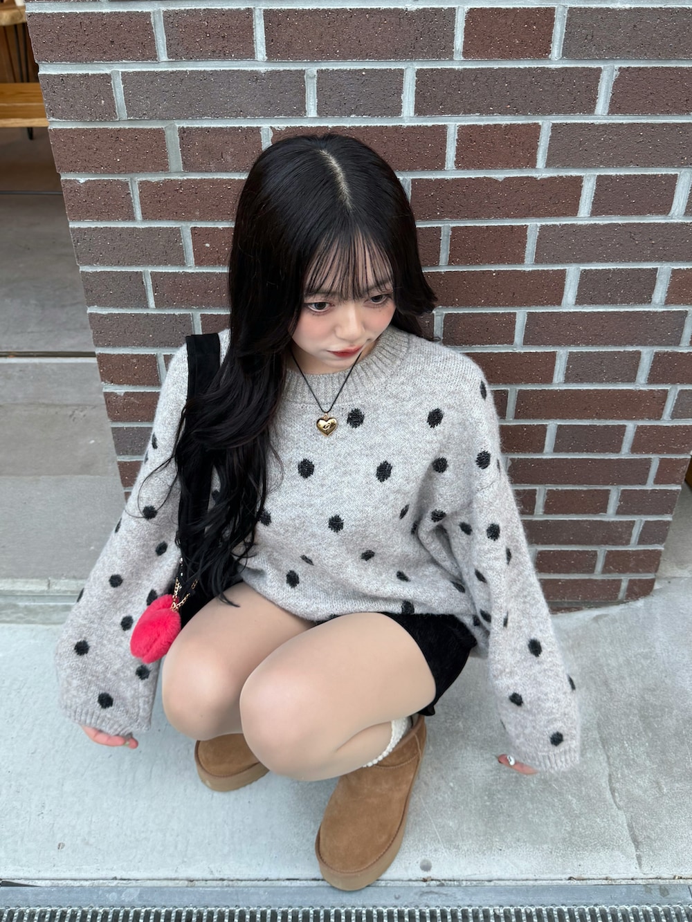 ブラウン系のブーツ、グレー系のニット/セーター、ブラック系のその他パンツを着用したレディースの冬コーディネートの2枚目の写真