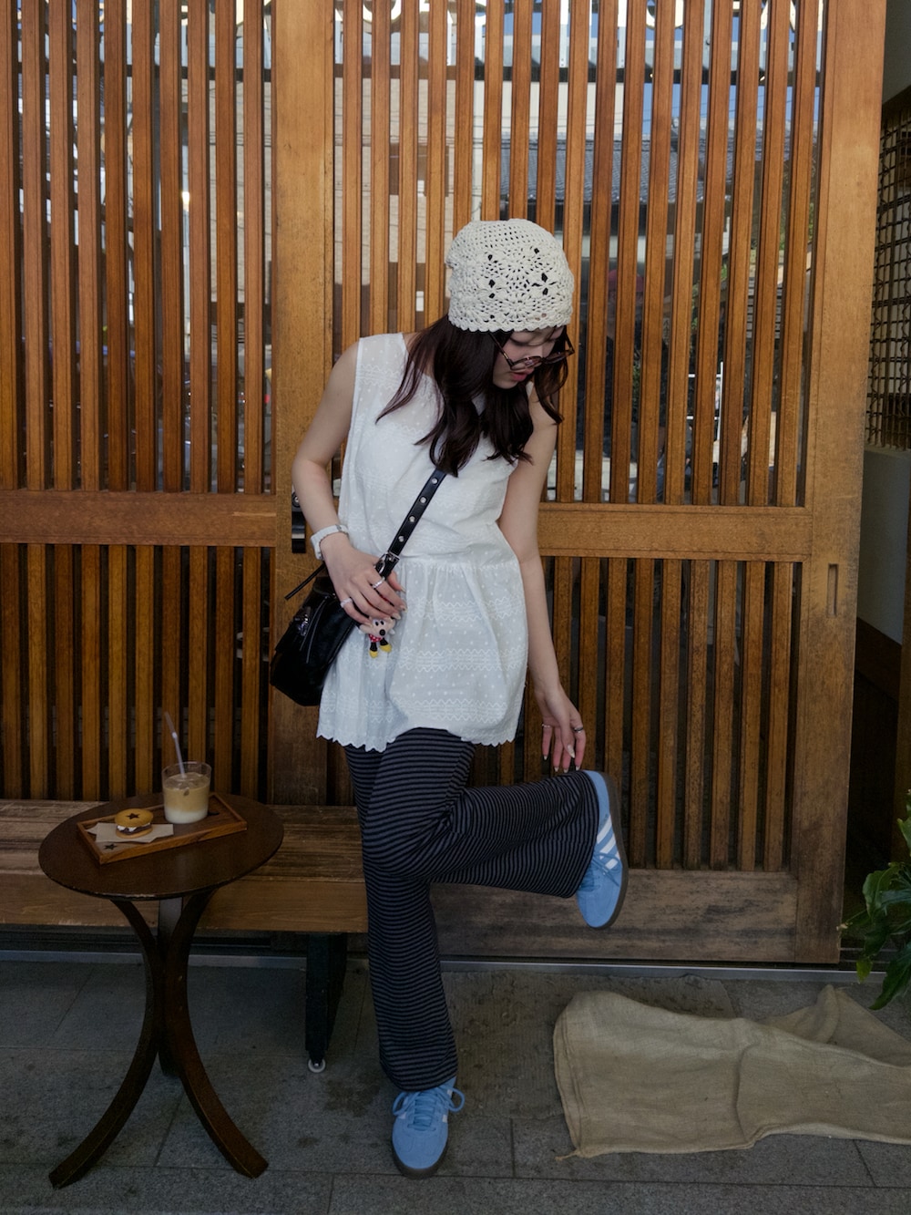 ホワイト系のワンピース、ブラック系のショルダーバッグ、ブルー系のスニーカーを着用したレディースの春コーディネートの3枚目の写真