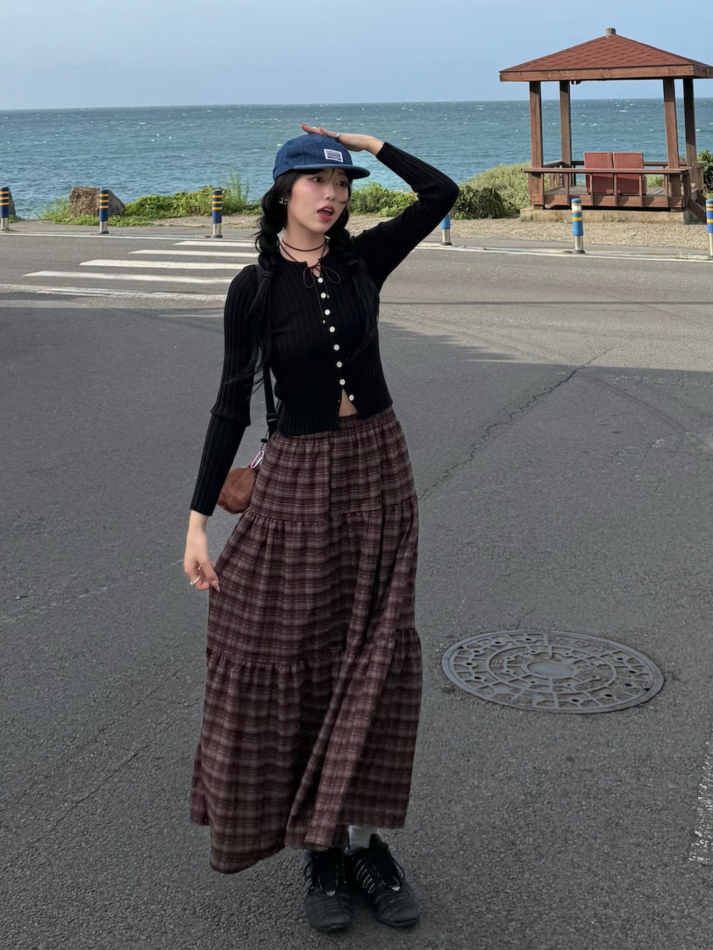 ブラック系のカーディガン/ボレロ、ブラウン系のスカート、ブラック系のスニーカーを着用したレディースの秋コーディネートの2枚目の写真