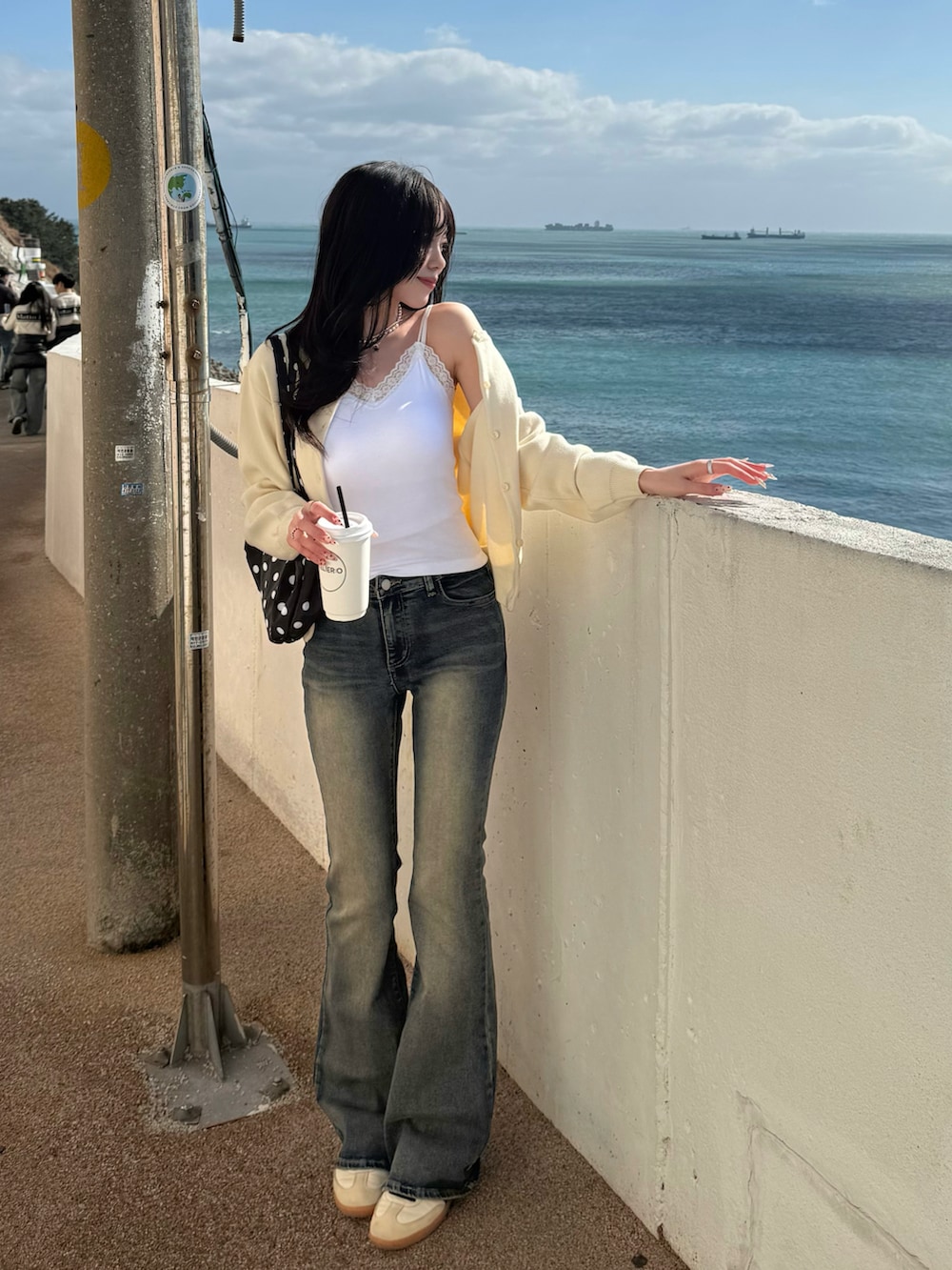 ホワイト系のスニーカー、ホワイト系のキャミソール、イエロー系のカーディガン/ボレロを着用したレディースの冬コーディネートの2枚目の写真