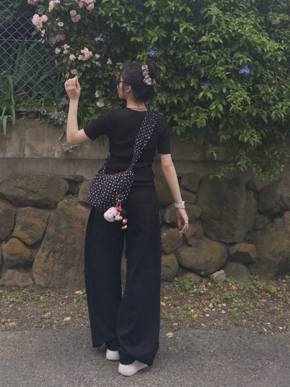 ブラック系のTシャツ/カットソー、ブラック系のショルダーバッグ、ブラック系のデニムパンツを着用したレディースの春コーディネートの3枚目の写真