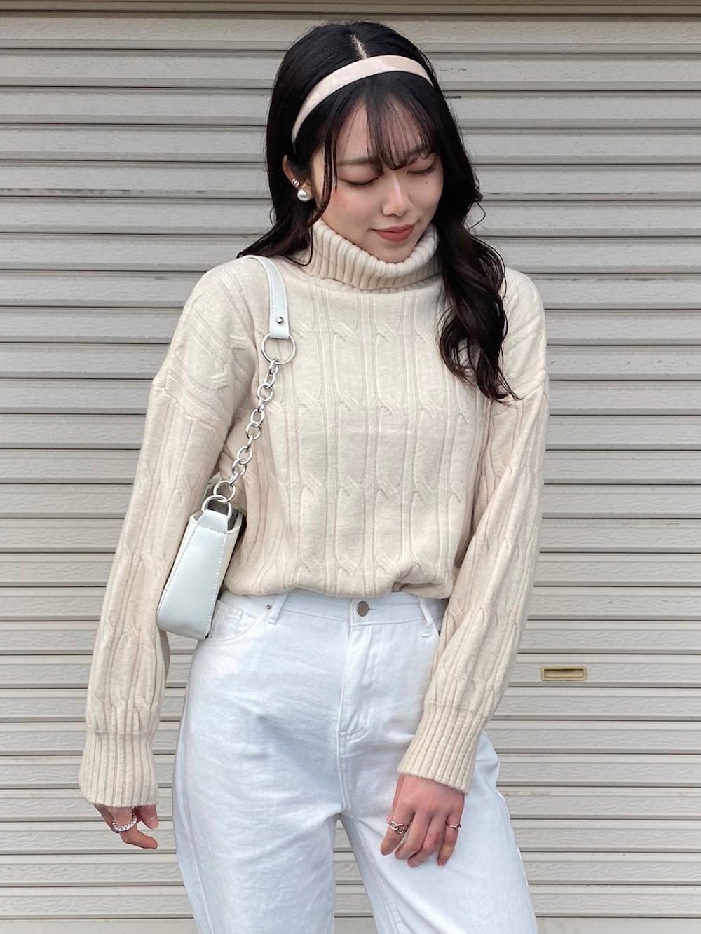 ホワイト系のスニーカー、ホワイト系のニット/セーター、ホワイト系のショルダーバッグを着用したレディースの冬コーディネートの3枚目の写真