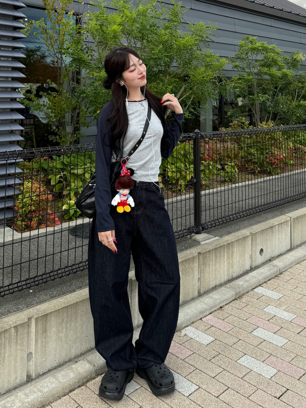 ブラック系のサンダル、グレー系のTシャツ/カットソー、ブルー系のデニムパンツを着用したレディースの秋コーディネートの2枚目の写真