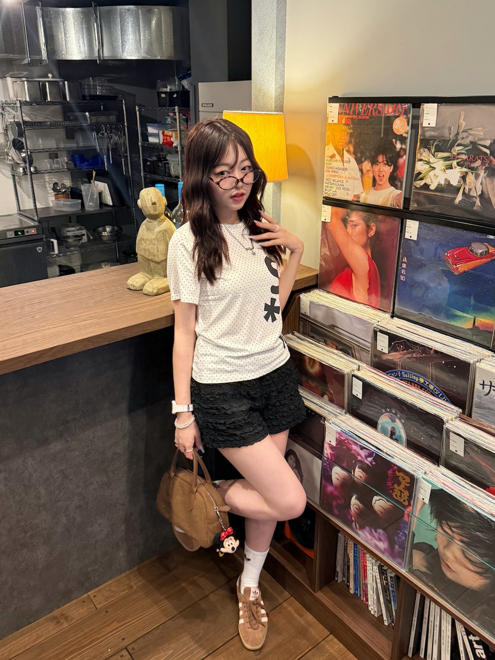 ブラック系のスウェットパンツ、ブラウン系のスニーカー、ブラウン系のハンドバッグを着用したレディースの夏コーディネートの2枚目の写真