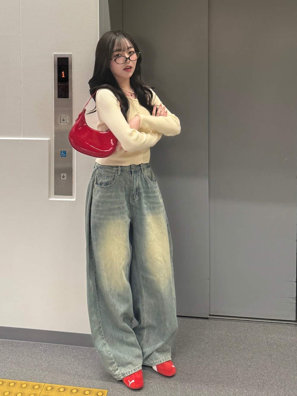 ホワイト系のカーディガン/ボレロ、ブルー系のデニムパンツ、レッド系のスニーカーを着用したレディースの春コーディネートの2枚目の写真