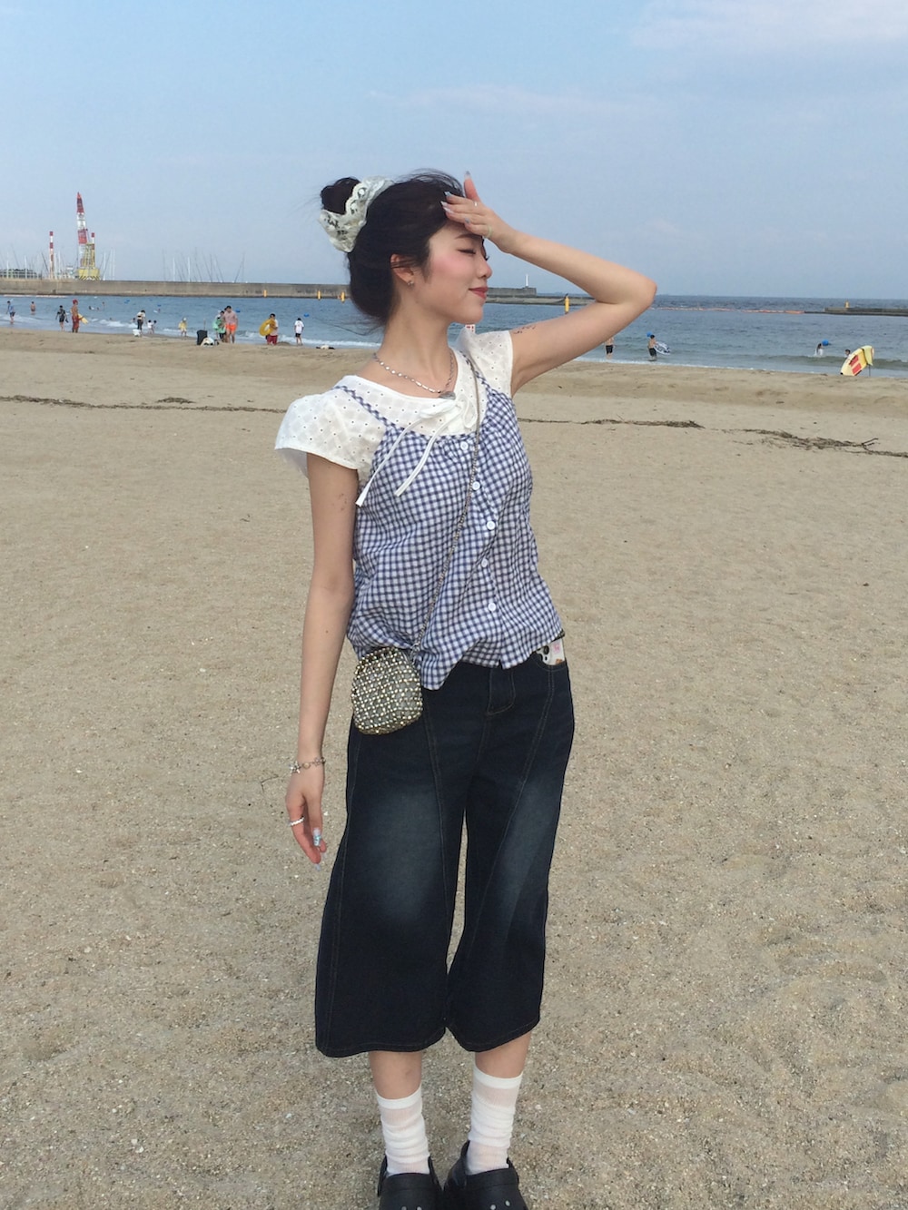 ブルー系のシャツ/ブラウス、ブルー系のデニムパンツ、シルバー系のショルダーバッグを着用したレディースの夏コーディネートの2枚目の写真