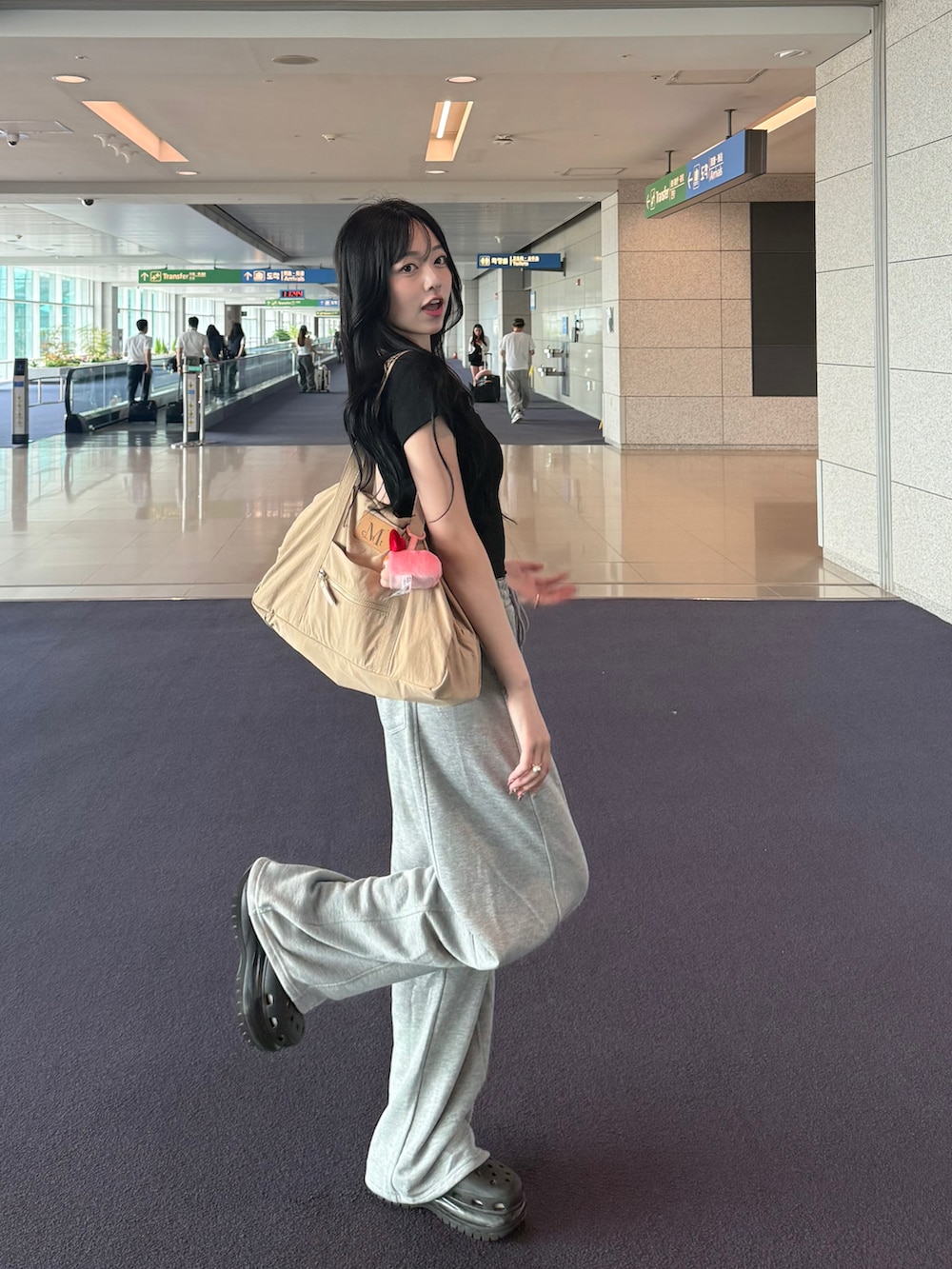 ブラック系のTシャツ/カットソー、グレー系のスウェットパンツ、ベージュ系のショルダーバッグを着用したレディースの夏コーディネートの2枚目の写真