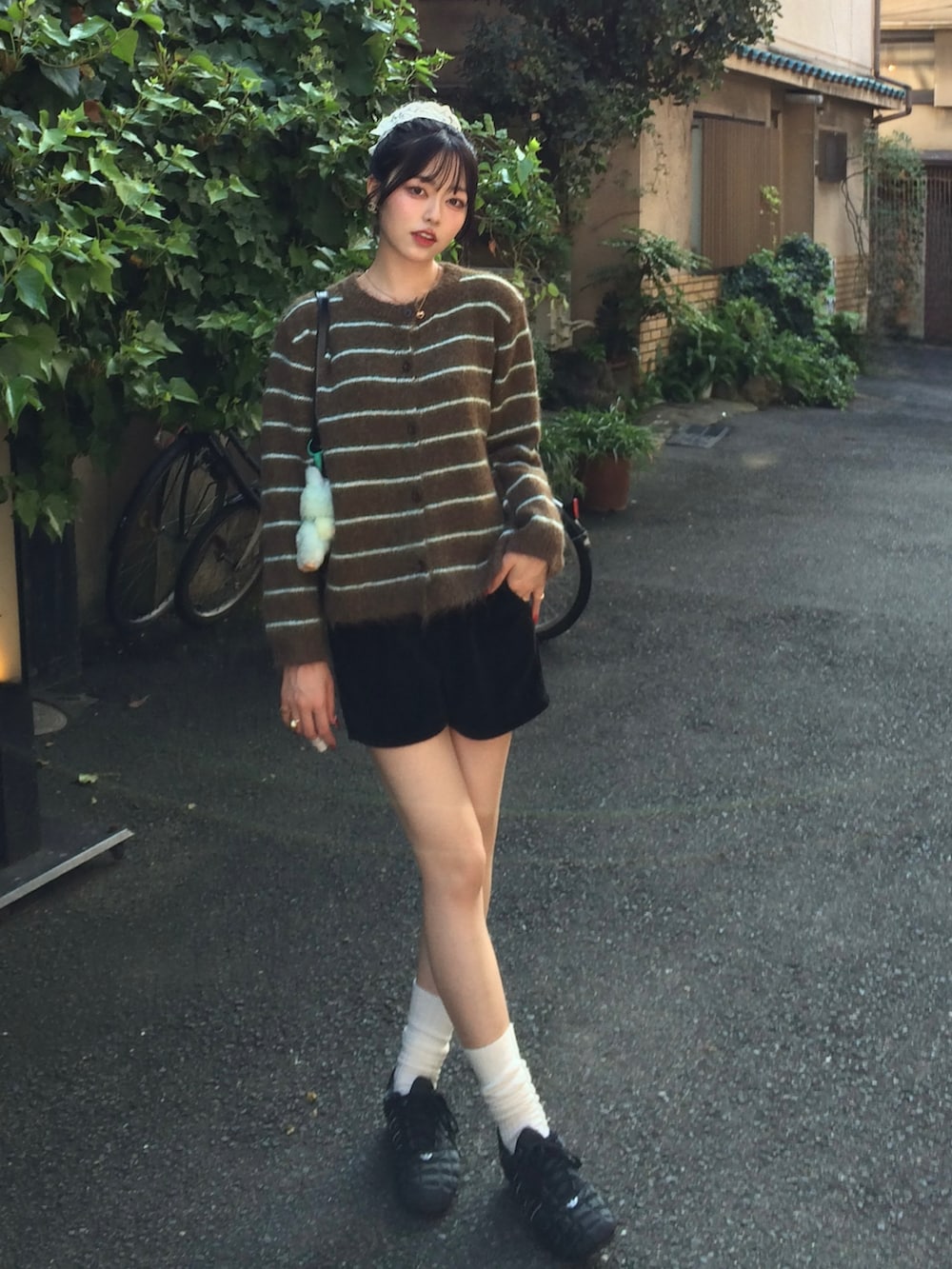 ブラウン系のカーディガン/ボレロ、ブラック系のその他パンツ、ブラック系のスニーカーを着用したレディースの秋コーディネートの2枚目の写真