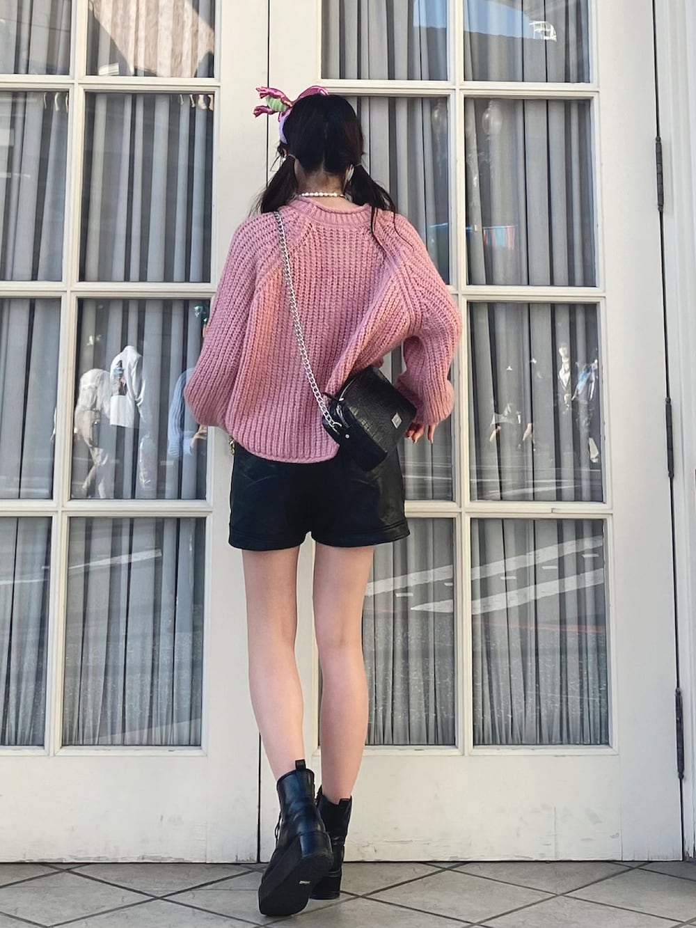 ピンク系のニット/セーター、ブラック系のその他パンツ、ブラック系のその他シューズを着用したレディースの春コーディネートの3枚目の写真