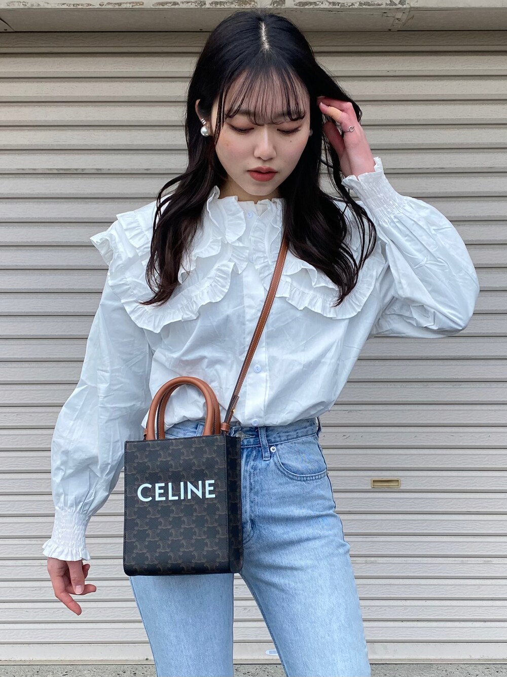 ホワイト系のTシャツ/カットソー、ブルー系のデニムパンツ、ブラック系のローファーを着用したレディースの冬コーディネートの2枚目の写真