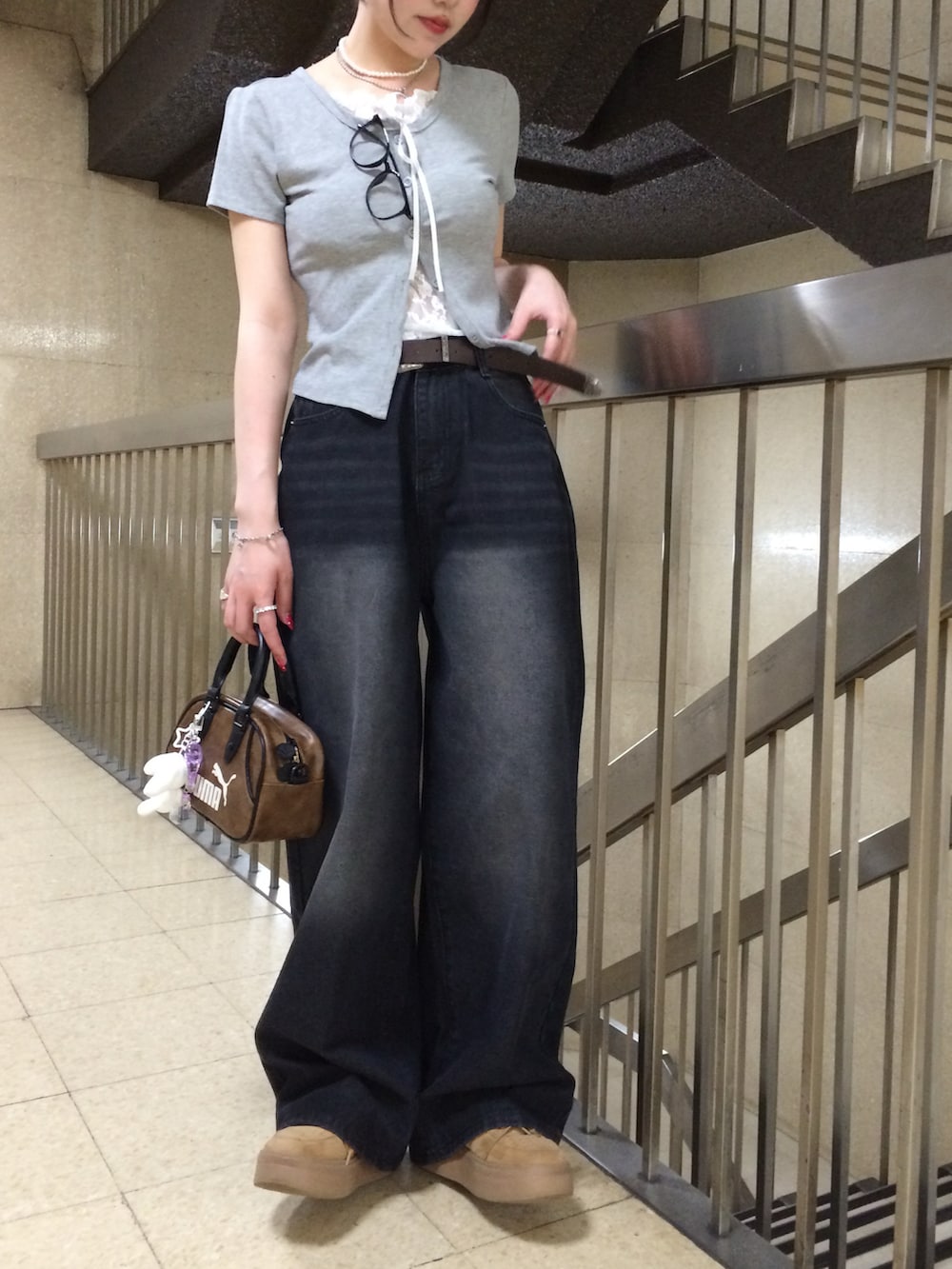 グレー系のTシャツ/カットソー、ブラック系のデニムパンツ、ブラウン系のスニーカーを着用したレディースの夏コーディネートの2枚目の写真