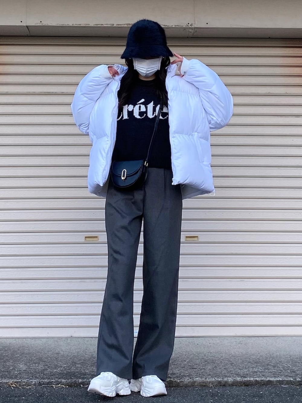 ブラック系のニット/セーター、ホワイト系のスニーカー、ブラック系のハットを着用したレディースの冬コーディネートの2枚目の写真