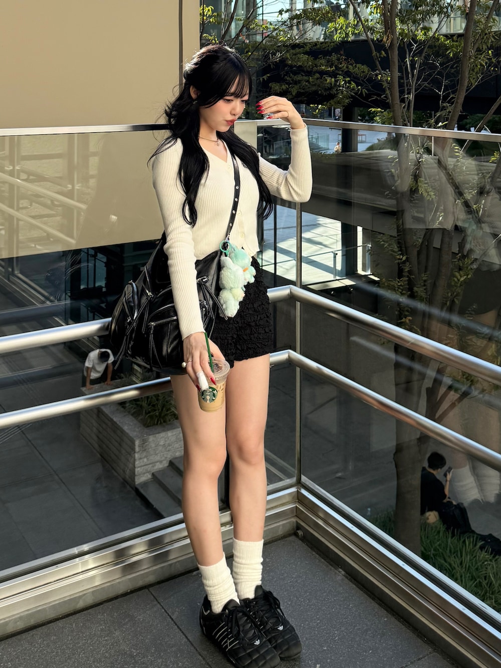 ホワイト系のカーディガン/ボレロ、ブラック系のスウェットパンツ、ブラック系のスニーカーを着用したレディースの秋コーディネートの2枚目の写真