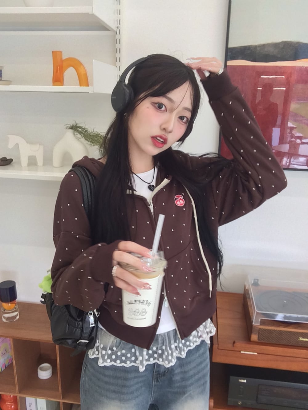 ブルー系のデニムパンツ、ブラウン系のパーカー、ブラック系のスニーカーを着用したレディースの秋コーディネートの4枚目の写真