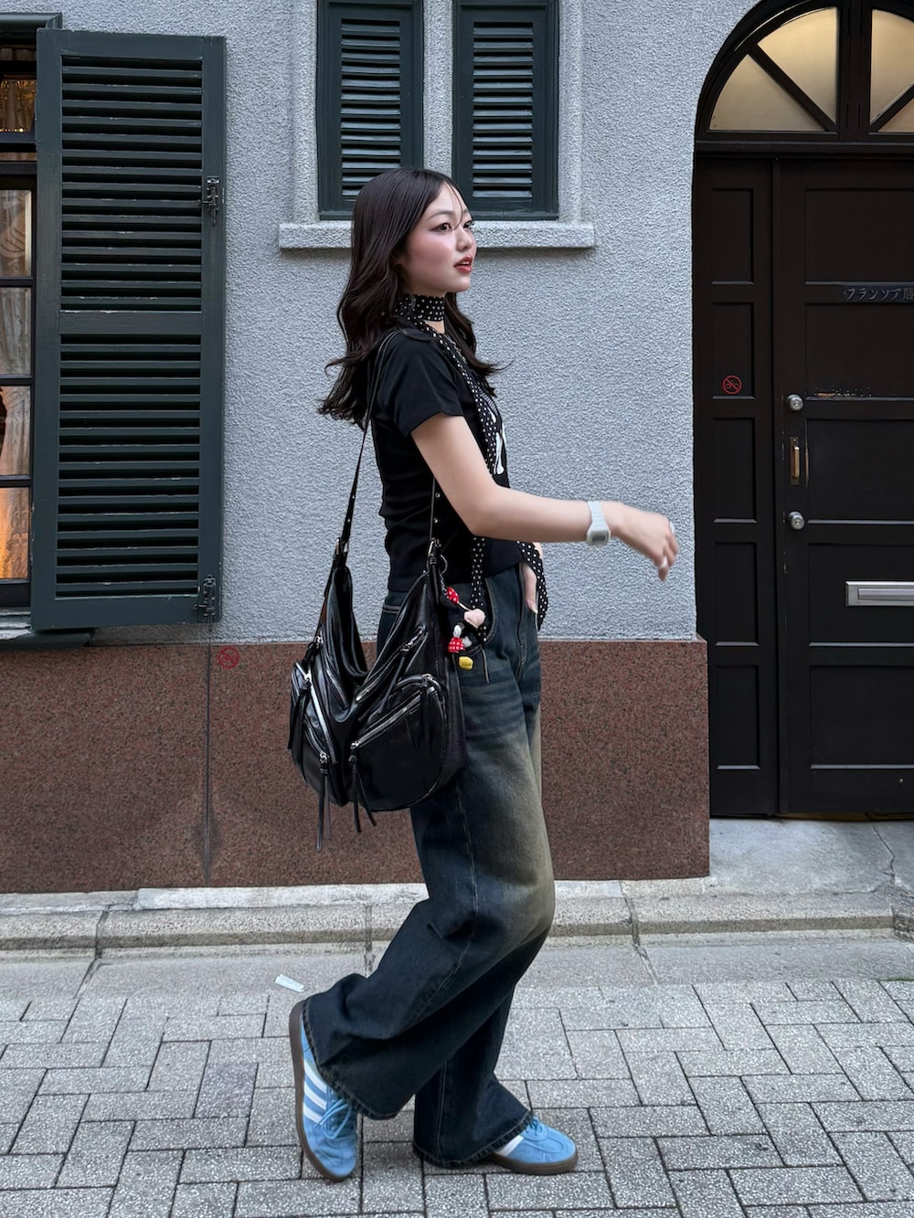 ブラック系のTシャツ/カットソー、ブラック系のショルダーバッグ、ブルー系のデニムパンツを着用したレディースの春コーディネートの2枚目の写真