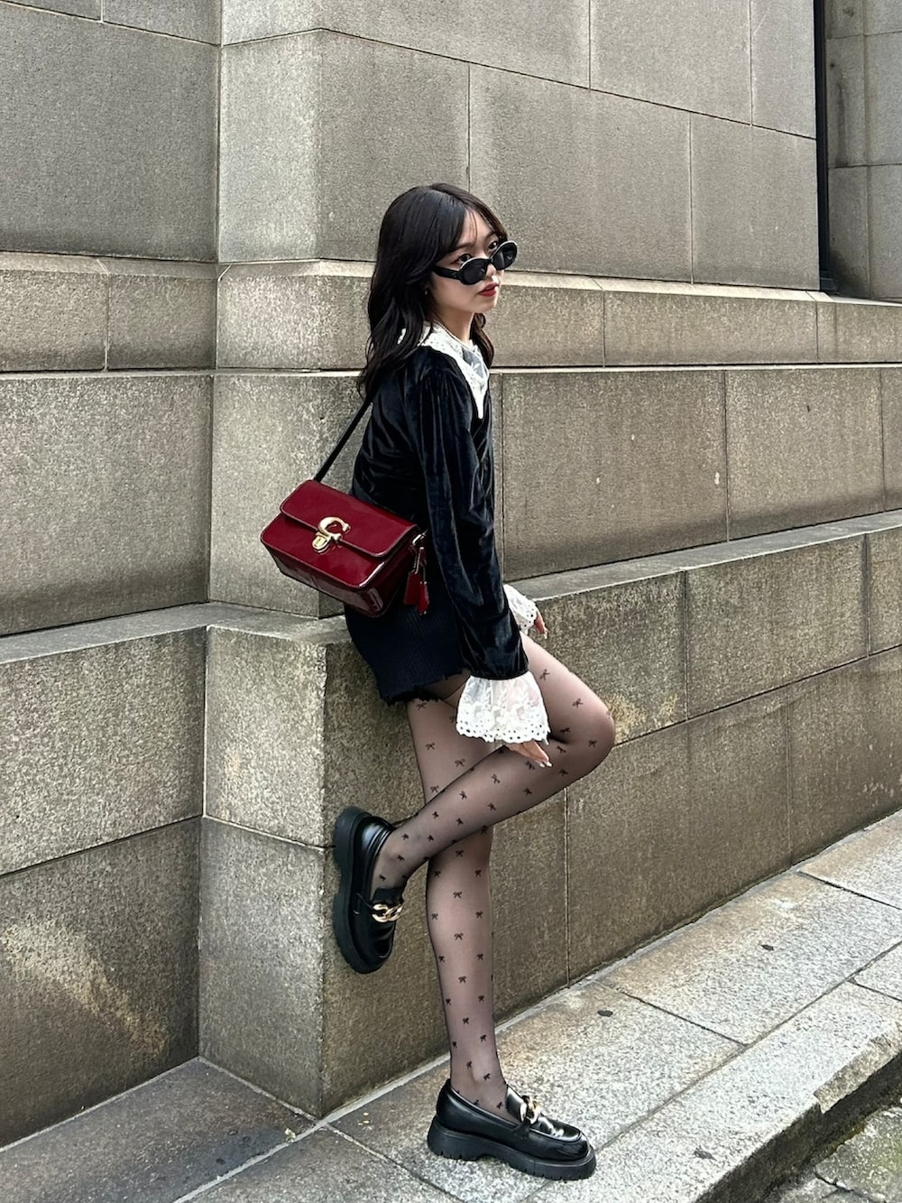 ブラック系のニット/セーター、レッド系のショルダーバッグ、ブラック系のその他パンツを着用したレディースの冬コーディネートの3枚目の写真