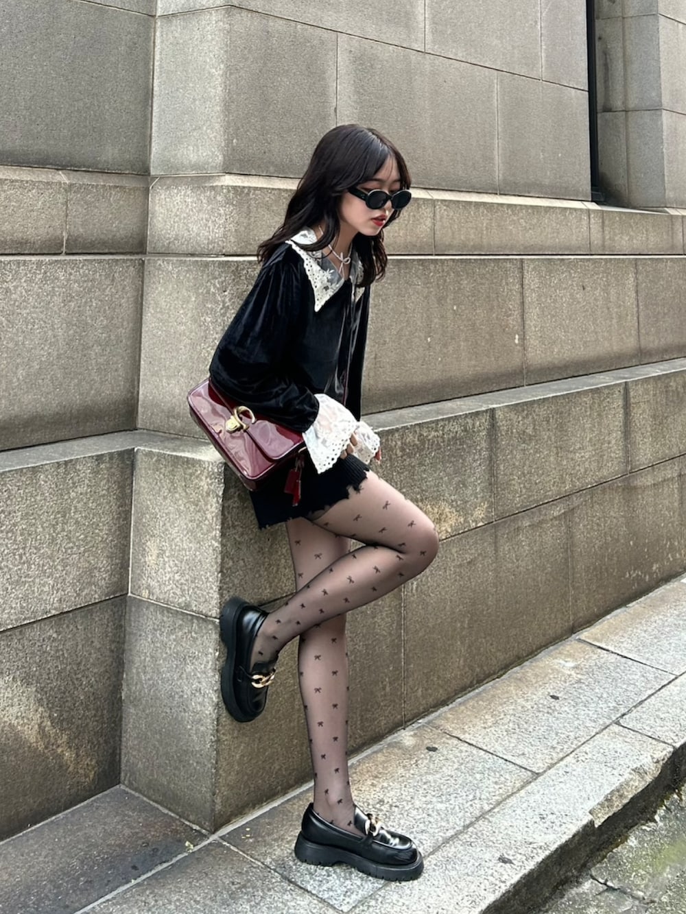 ブラック系のニット/セーター、レッド系のショルダーバッグ、ブラック系のその他パンツを着用したレディースの冬コーディネートの2枚目の写真